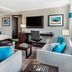 Four Points by Sheraton London suite with sofa seating, desk, wall-mounted TV and murphy bed