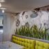 Tropica Beach Hotel San Juan lounge with tufted seating and tropical floral wall mural
