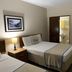 Canario Lagoon Hotel in San Juan: guest room with two twin beds, bedside lamps, and mirrored closet