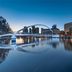 Kempinski Hotel Beijing Yansha Center in Beijing with a lit arch bridge reflected on calm water at dusk