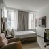 Club Quarters Hotel Faneuil Hall, Boston guest room with bed, desk, chair, and windows