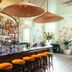 Hotel Saint Vincent bar in New Orleans with woven pendant lights and orange bar stools