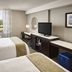 Waterfront Hotel Downtown Burlington room with twin beds, desk, TV, and window view in Burlington