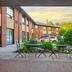 Comfort Inn Kingston - Highway 401 patio with tables, chairs, and parked cars in Kingston