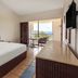 Cozumel Hotel & Resort guest room with king bed, balcony seating, and ocean view in Cozumel