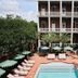 Hotel Saint Vincent in New Orleans with courtyard pool, lounge chairs, umbrellas and palm trees