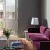 Hotel Saint Vincent in New Orleans lounge with purple sofa, amber chair, glass coffee table and balcony door