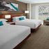 Delta Hotels by Marriott London Armouries guest room with two beds, desk and city-view window