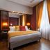 Atlante Garden Hotel Rome guest room with king bed, warm lighting and tall draped window