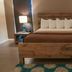 Thunderbird Boutique Hotel Las Vegas room with rustic wooden bed, bedside lamps, and patterned rug
