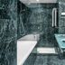 AC Hotels by Marriott La Rioja bathroom with marble walls, bathtub, glass sink vanity and shower in Logroño