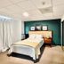 Sj Suites Hotel San Juan guest room with bed, nightstands, teal accent wall and mirrored closet