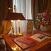 Residenza Paolo VI in Rome: elegant bedside table with lamp, flowers, and open book