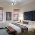 Hotel Indigo Boston Garden guest room with king bed, bench, and two windows in Boston