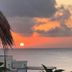 Flamingo Hotel Cozumel sunset over the ocean with palm leaves and seaside terrace