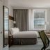 Club Quarters Hotel Faneuil Hall, Boston guest room with bed, desk, chair, and city views