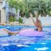 Grand Oasis Tulum in Akumal: guests on floaties raising hands in a resort pool amid tropical greenery