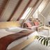 Dom Hotel Augsburg attic room with bed, sofa, desk, and skylight windows