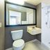 Comfort Inn Kingston - Highway 401 bathroom with toilet, sink, mirror and roll-in shower