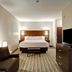 Best Western London Airport Inn & Suites guest room with king bed, sofa, TV, and bench in London