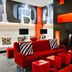 Ameritania at Times Square New York lounge with red sofas, zebra pillows, and modern fireplace