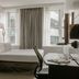 Club Quarters Hotel Faneuil Hall, Boston guest room with bed, desk and city-view windows