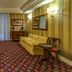 Atlante Garden Hotel in Rome lounge with striped walls, patterned carpet, sofa, armchairs and window drapes