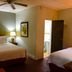 Casa del Caribe Inn in San Juan guest room with two beds, lamp, ceiling fan and open bathroom doorway