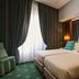 Atlante Garden Hotel Rome guest room with twin beds, green drapes, and mirrored wall