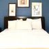 Sj Suites Hotel in San Juan guest room with bed, nightstand, and blue accent wall