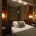 Atlante Garden Hotel Rome guest room with single bed, desk, lamps and mirrored wood paneling