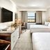 Omni Parker House Boston guest room with two beds, desk, and city view through window