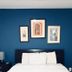 Sj Suites Hotel San Juan guest room with blue accent wall, framed art, and neatly made bed