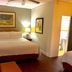 Casa del Caribe Inn in San Juan, guest room with king bed, bedside lamps, and hardwood floor