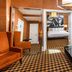 Ameritania at Times Square in New York: suite seating area with bedroom and black-and-tan checkered carpet