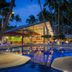Araiza Palmira in La Paz with a lit outdoor pool and palm trees at dusk