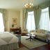 Park International Hotel London guest room with four-poster bed, sofa, armchair and large windows
