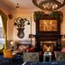 The Hotel Chelsea in New York lounge with ornate fireplace, chandelier, and colorful wall art