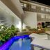 Tropica Beach Hotel San Juan courtyard with lit pool, lounge chairs and outdoor bar at night