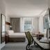 Club Quarters Hotel Faneuil Hall, Boston guest room with bed, desk, chair and city-view windows