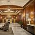 Omni Parker House Boston lobby with wood-paneled walls, chandelier, seating area, and marble floors