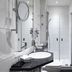 Dom Hotel Augsburg bathroom with glass walk-in shower, vanity sink, and wall mirror