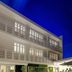 Tropica Beach Hotel in San Juan, exterior with lit balconies against a deep blue evening sky