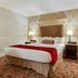 Prince Conti Hotel New Orleans guest room with king bed, bedside lamps, and patterned carpet