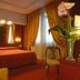 Atlante Garden Hotel Rome guest room with double bed, warm lighting, and floral arrangement