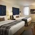 Hotel Indigo Boston Garden Boston guest room with two beds, TV, desk and window light