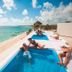 Grand Oasis Tulum in Akumal: rooftop pool overlooking the beach and turquoise sea with guests relaxing.