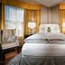 Staypineapple Union Square San Francisco guest room with king bed, golden curtains and city windows
