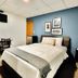 Sj Suites Hotel in San Juan guest room with queen bed, desk, wall-mounted TV and blue accent wall