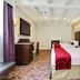 Prince Conti Hotel New Orleans guest room with two beds, patterned carpet and wall-mounted TV